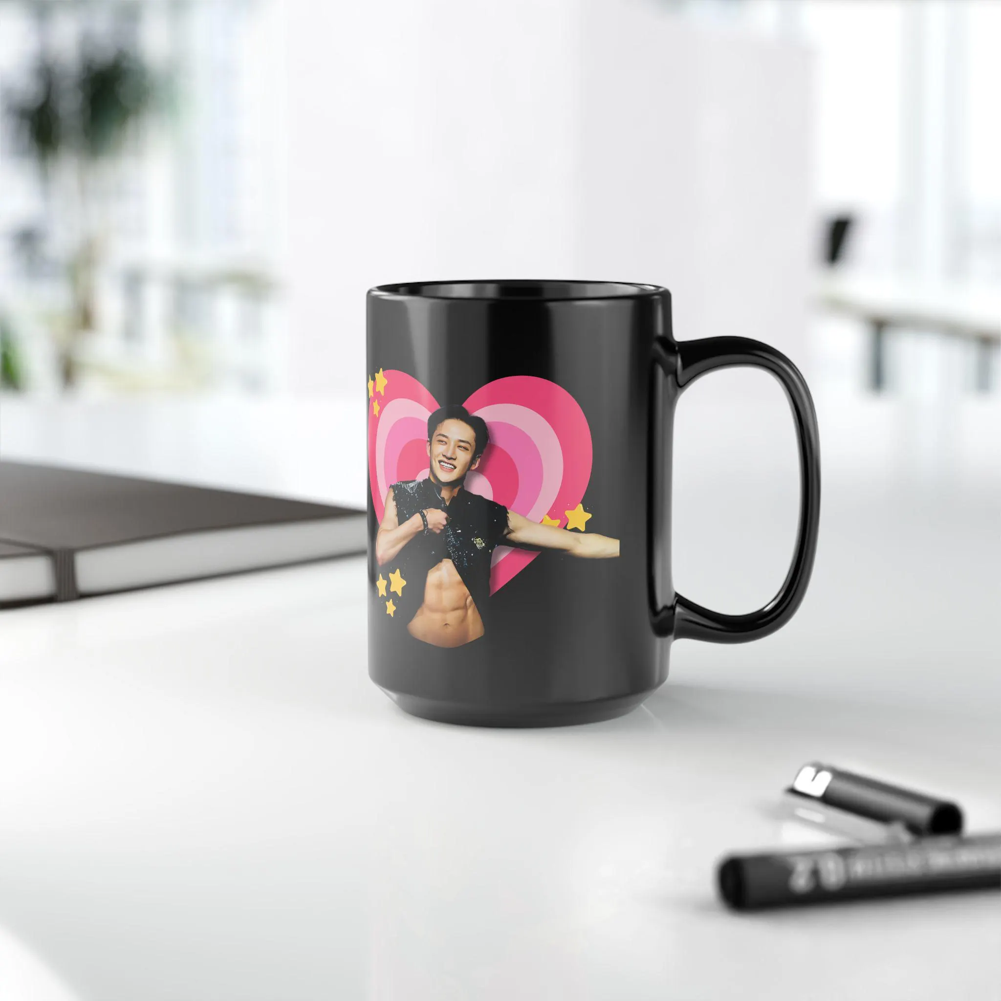 Black ceramic mug featuring K-pop artist Bang Chan in front of a pink heart graphic with yellow stars
