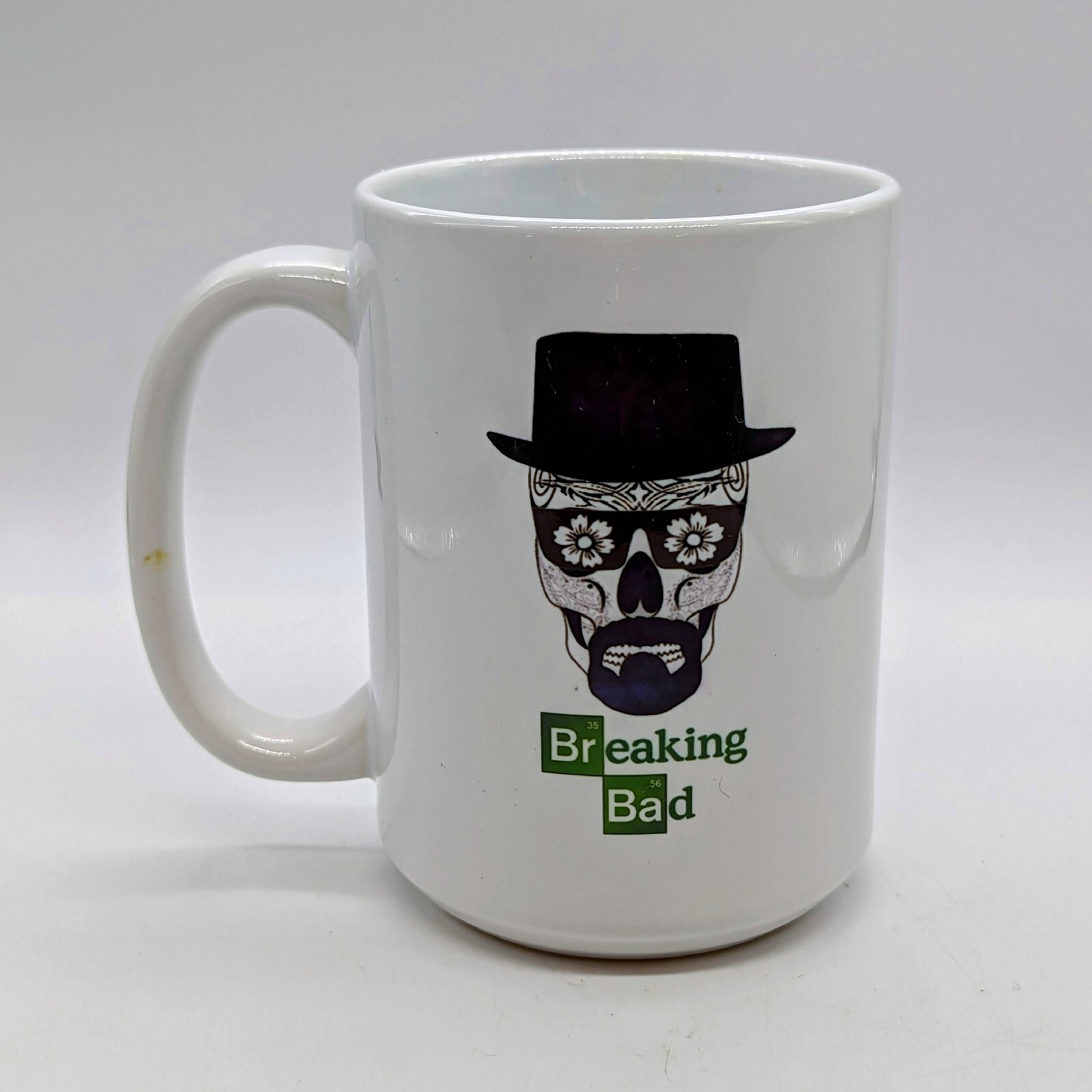 White ceramic mug featuring Heisenberg sugar skull graphic with Breaking Bad logo