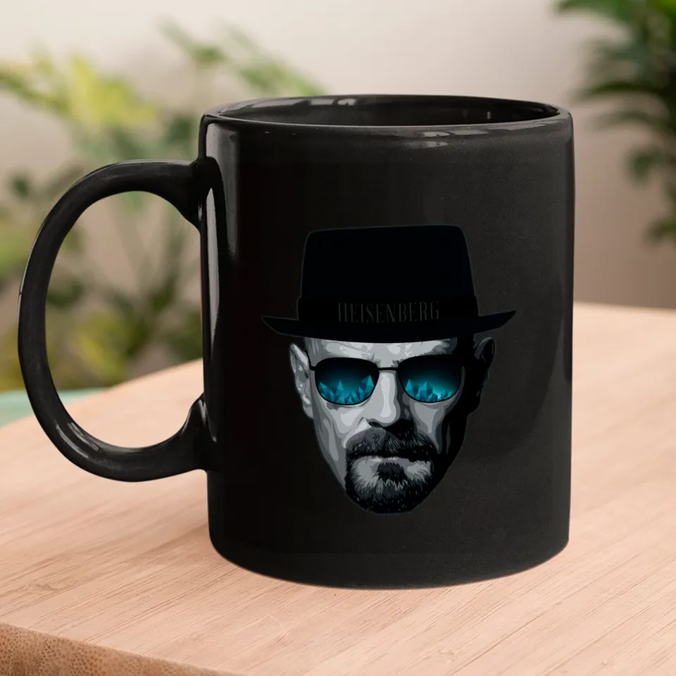 Black Heisenberg ceramic mug sitting on a wooden table surface