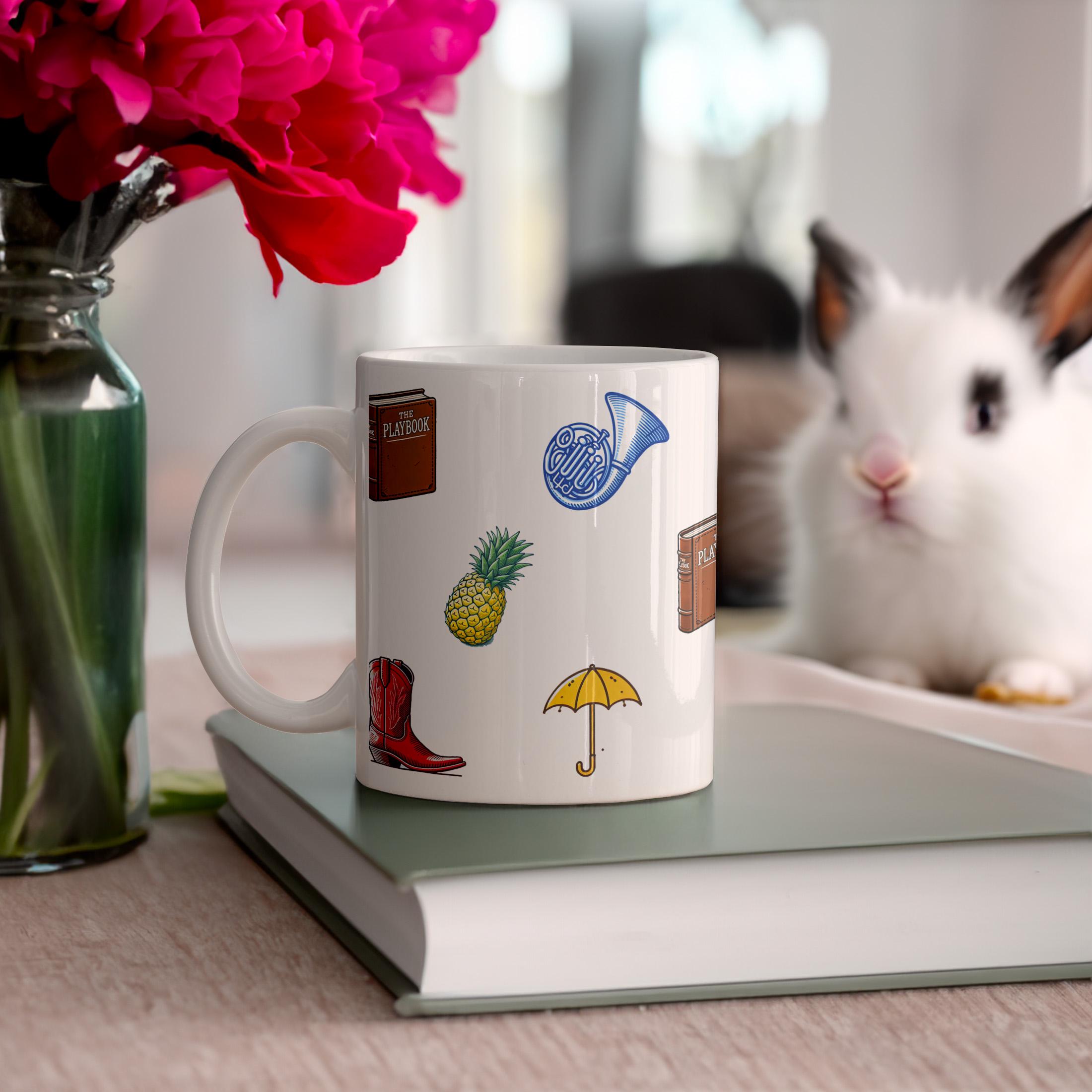 Close up of a ceramic mug with a pattern of icons including red cowboy boots and the playbook book from How I Met Your Mother on a rainbow background