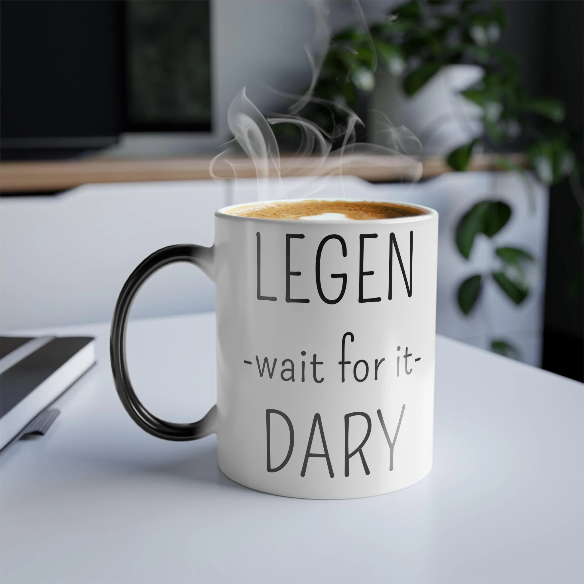 Closeup of color changing ceramic mug with legendary text and coffee on a white desk