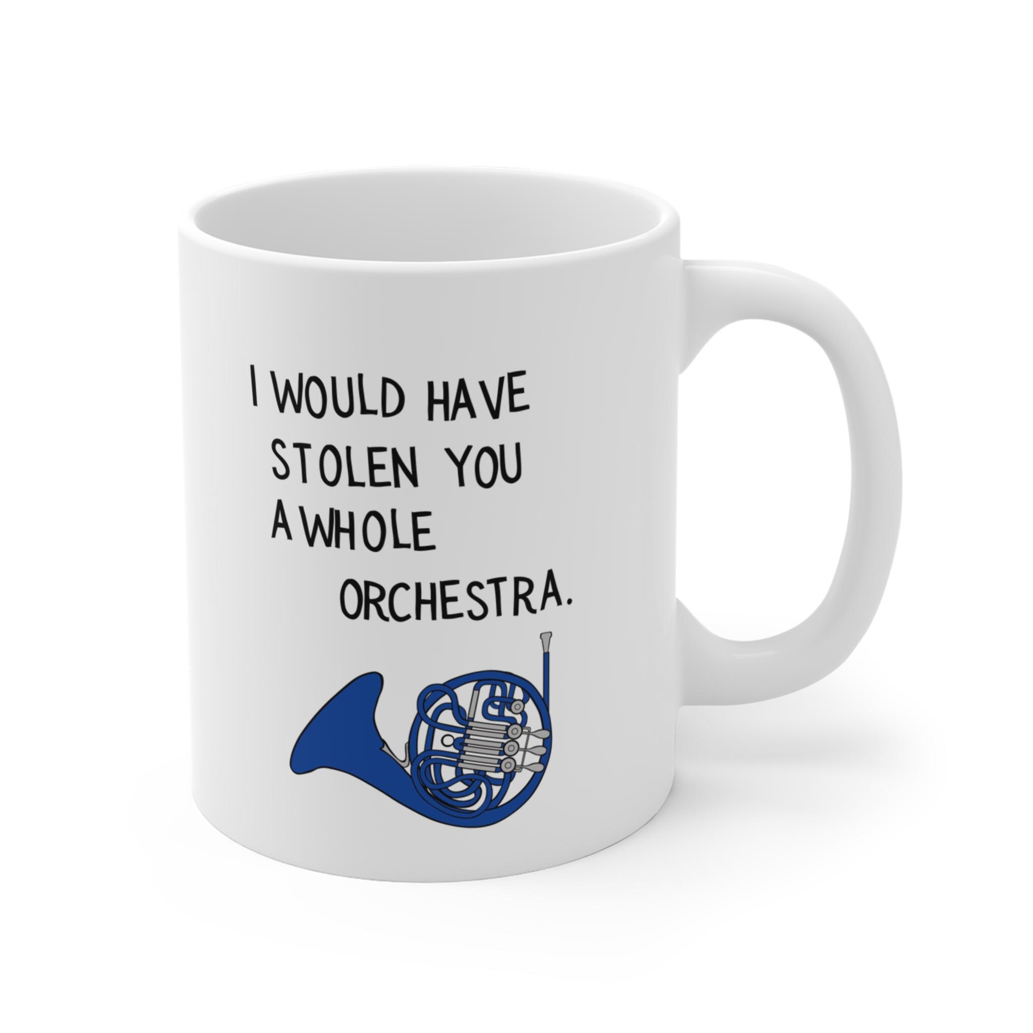 Side view of a white ceramic mug with blue musical horn design and quote about stealing an orchestra