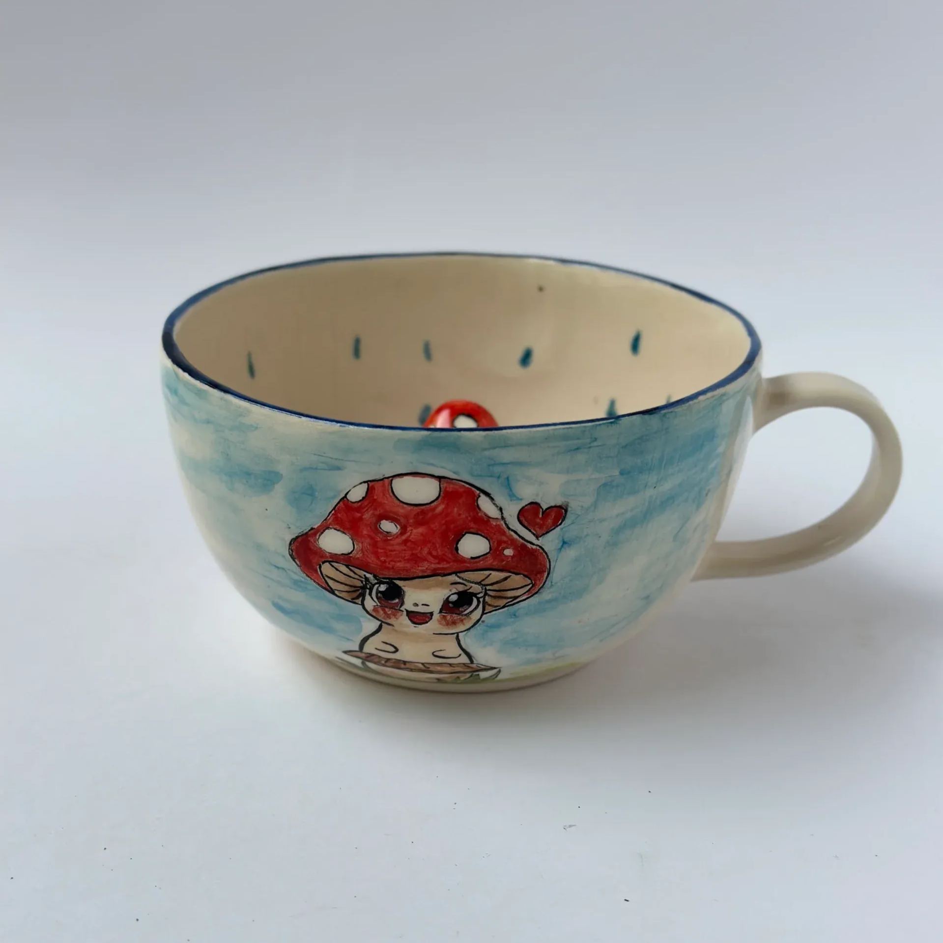 Handmade ceramic coffee mug with mushroom pattern and glossy finish