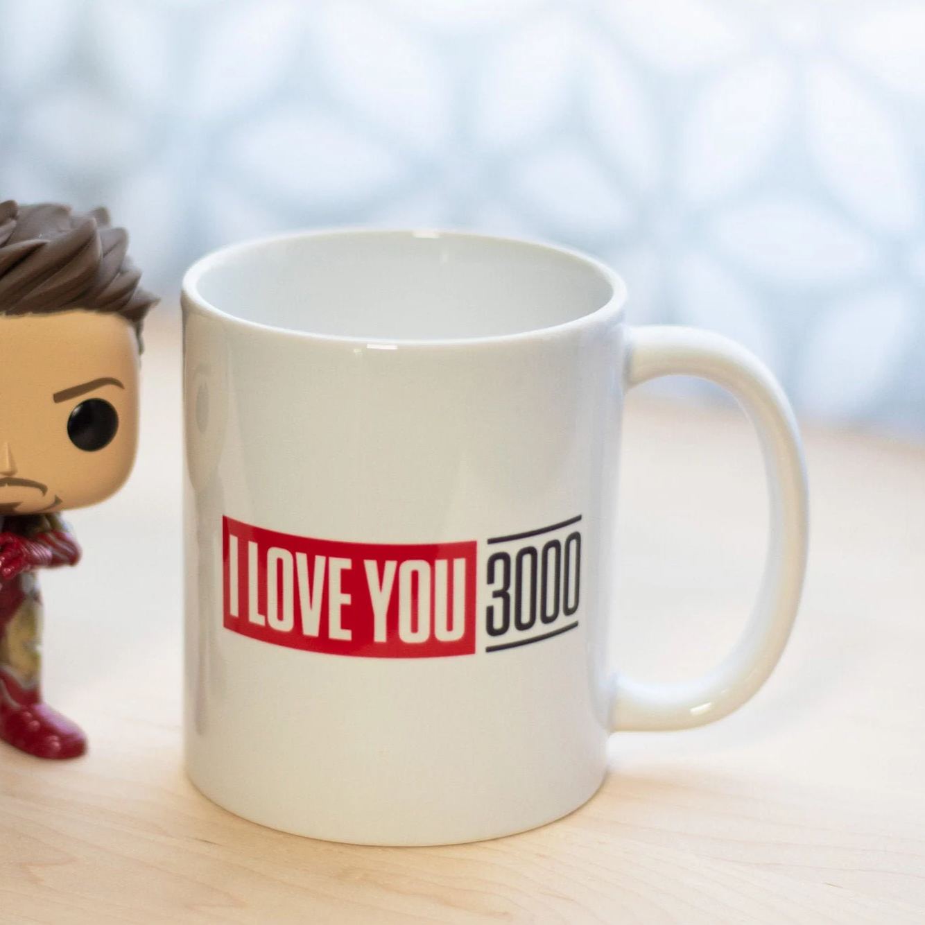Side view of white coffee mug with black handle and rim featuring text print