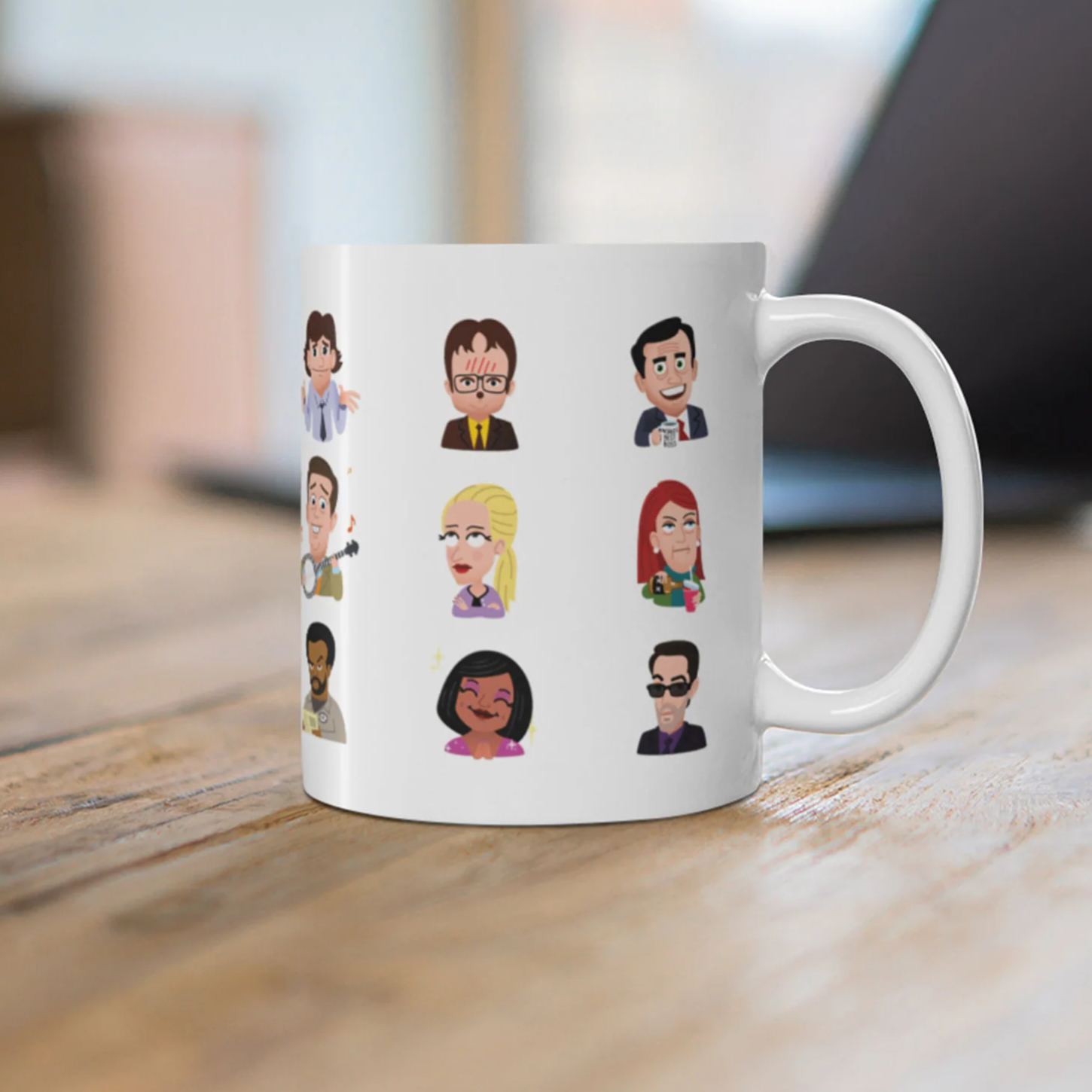 Side view of a white ceramic mug with character head icons sitting on a wooden table