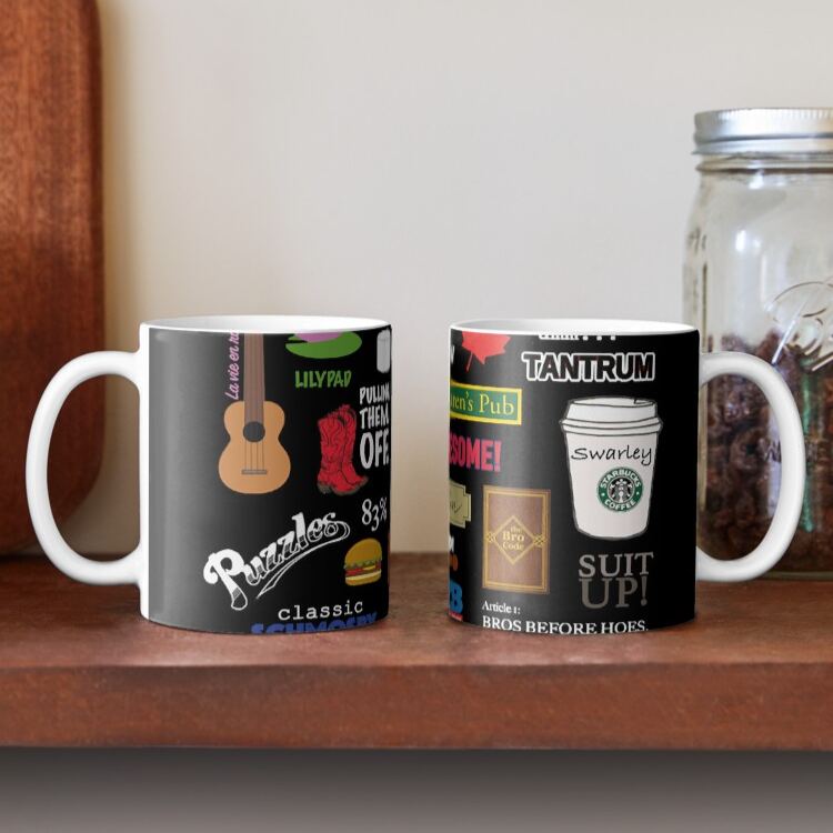 Two ceramic mugs displayed on a wood shelf showing the full wraparound design with red boots and yellow umbrella icons