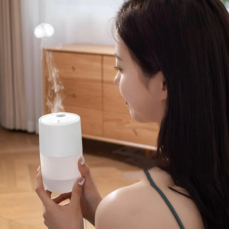 Young woman holding a white jellyfish-inspired humidifier, watching the mist rise in a softly lit bedroom.