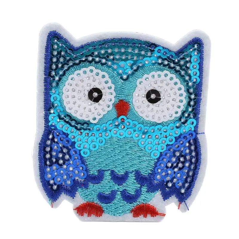 A blue sequin owl on a white background.