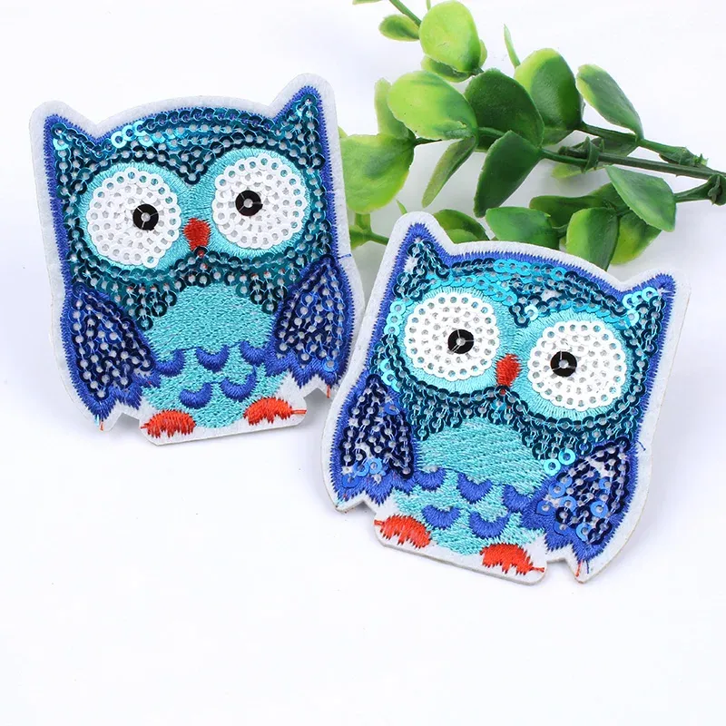 Two sequin owls sitting next to each other.