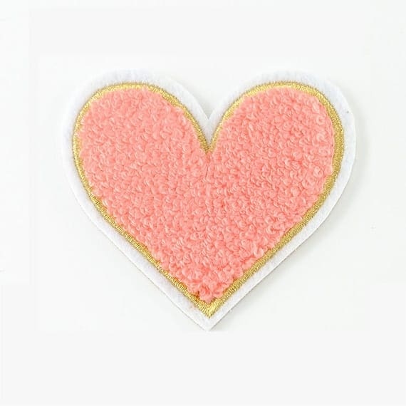 A pink heart shaped patch on a white background.