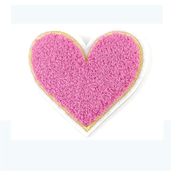 A pink heart shaped patch on a white background.