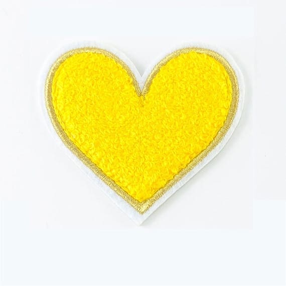 A yellow heart shaped patch on a white background.