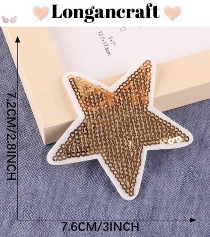 A gold sequin star is sitting next to a frame.