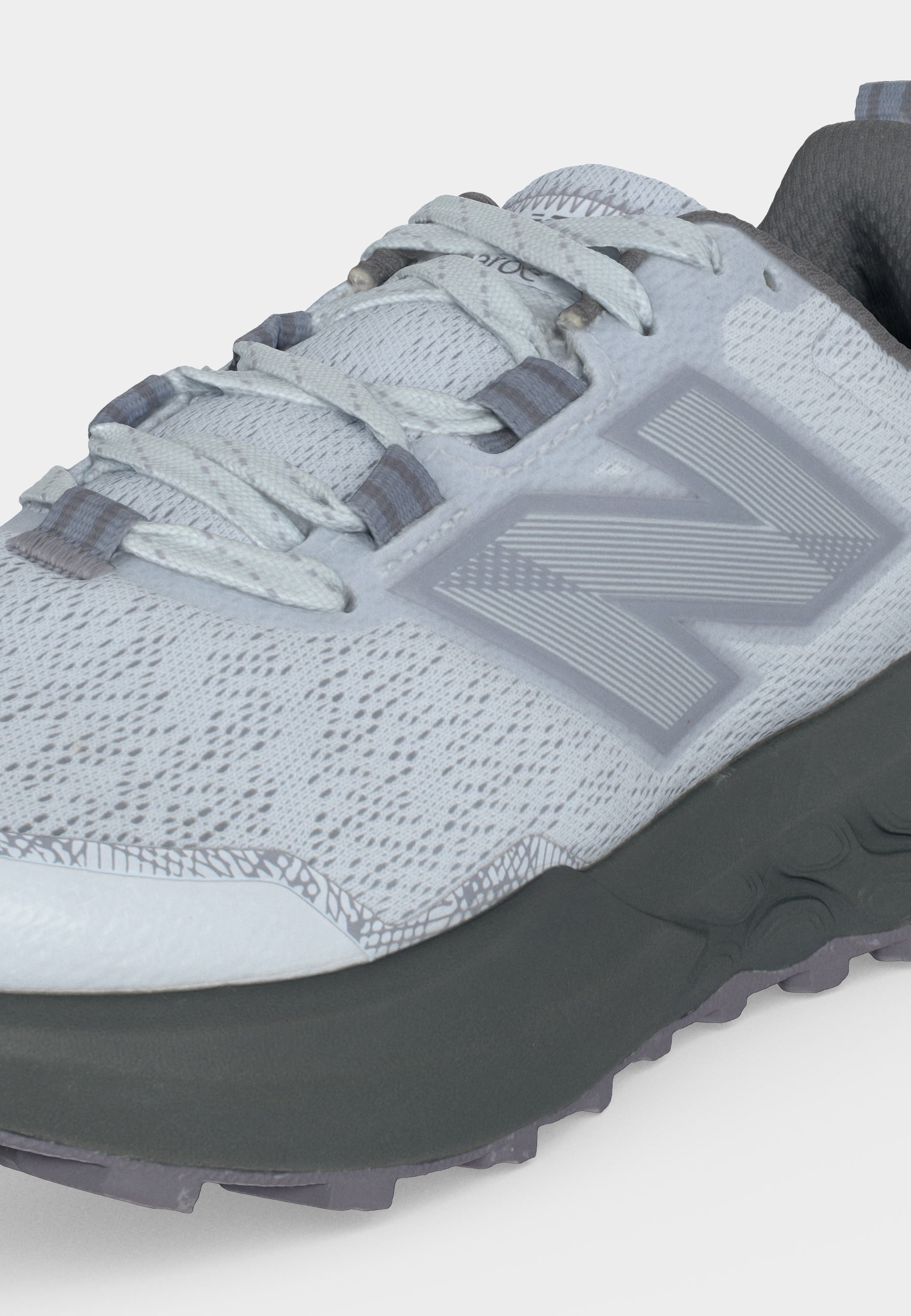 Zapatilla deportiva gris clara con cordones blancos, parte superior de malla transpirable, suela gris oscura y un gran logotipo estilizado "N" en el lateral.