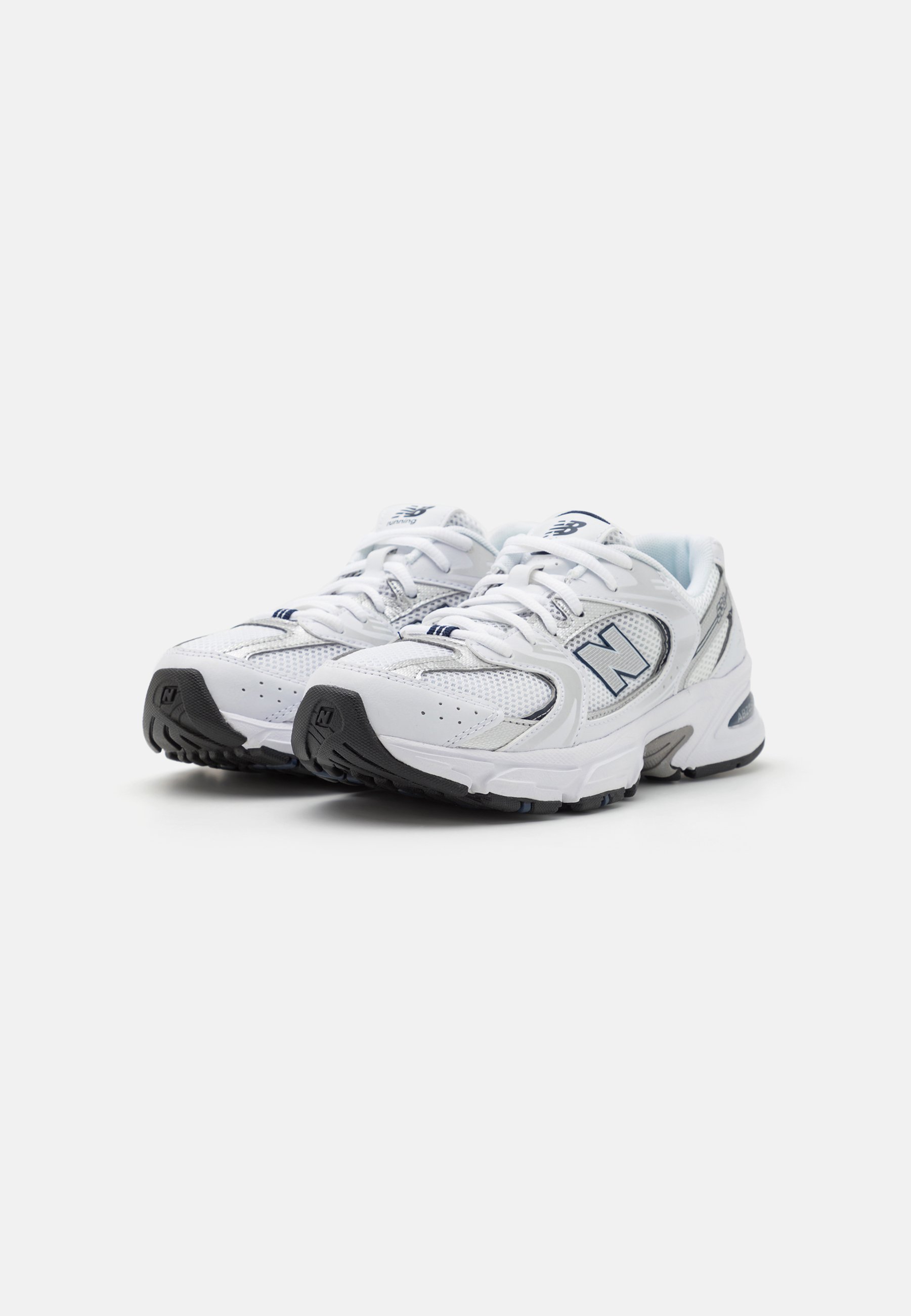 Zapatillas deportivas blancas con parte superior de malla, collar acolchado y suela de goma negra; presentan un logo bordado y acentos en contraste.