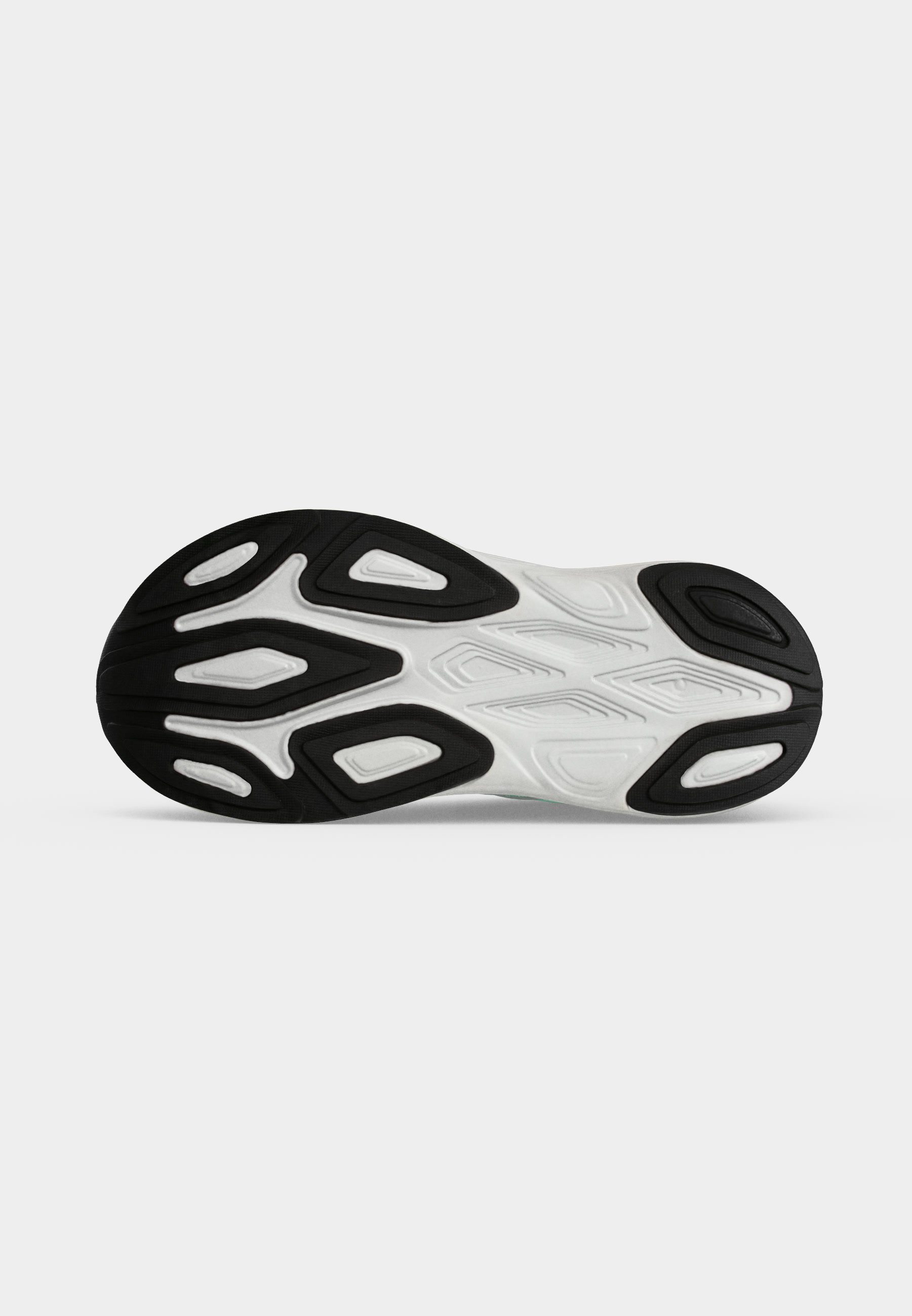Suela de una zapatilla deportiva blanca con patrones de goma negra diseñados para agarre y durabilidad.