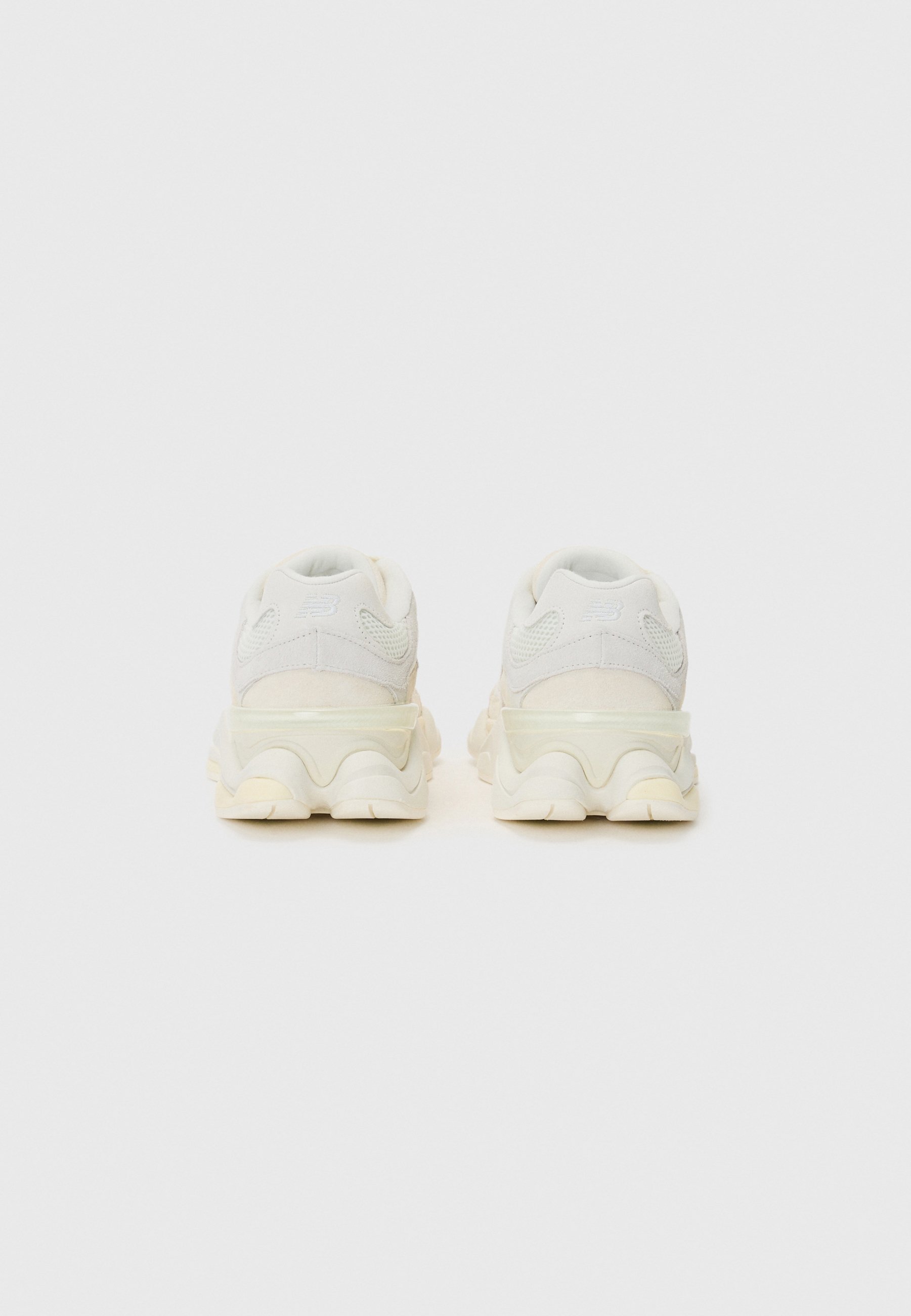 Zapatillas blancas gruesas con parte superior de tejido texturizado, suela semitransparente y diseño de media suela ondulada. Talón reforzado y cuello acolchado.