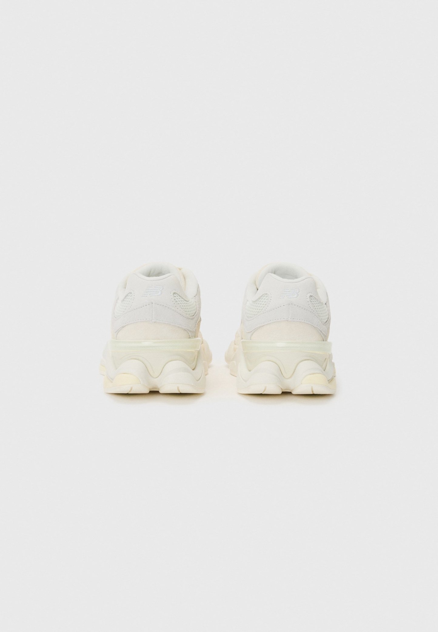Zapatillas blancas gruesas con parte superior de tejido texturizado, suela semitransparente y diseño de media suela ondulada. Talón reforzado y cuello acolchado.