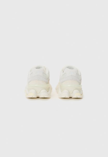 Zapatillas blancas gruesas con parte superior de tejido texturizado, suela semitransparente y diseño de media suela ondulada. Talón reforzado y cuello acolchado.