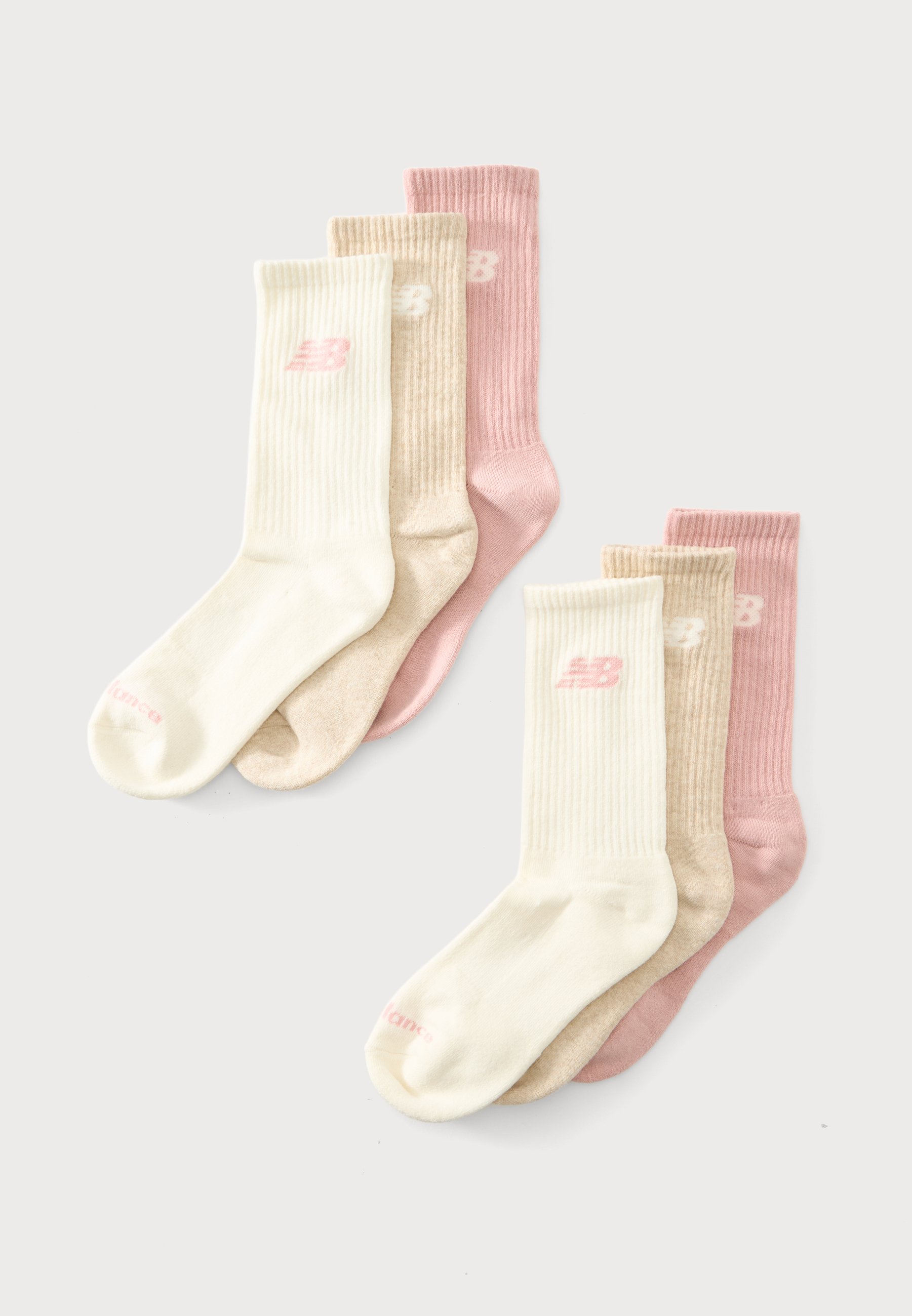 Tres pares de calcetines de canalé hasta la pantorrilla en crema, beige y rosa, cada uno con un pequeño logo cerca de la parte superior, dispuestos superpuestos sobre un fondo blanco.