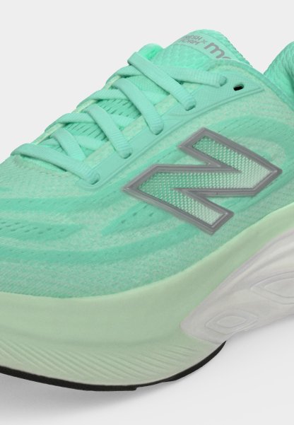 Primer plano de una zapatilla de correr New Balance color verde menta con parte superior de malla, collarín acolchado, cordones y una suela blanca acolchada con banda de rodadura negra.