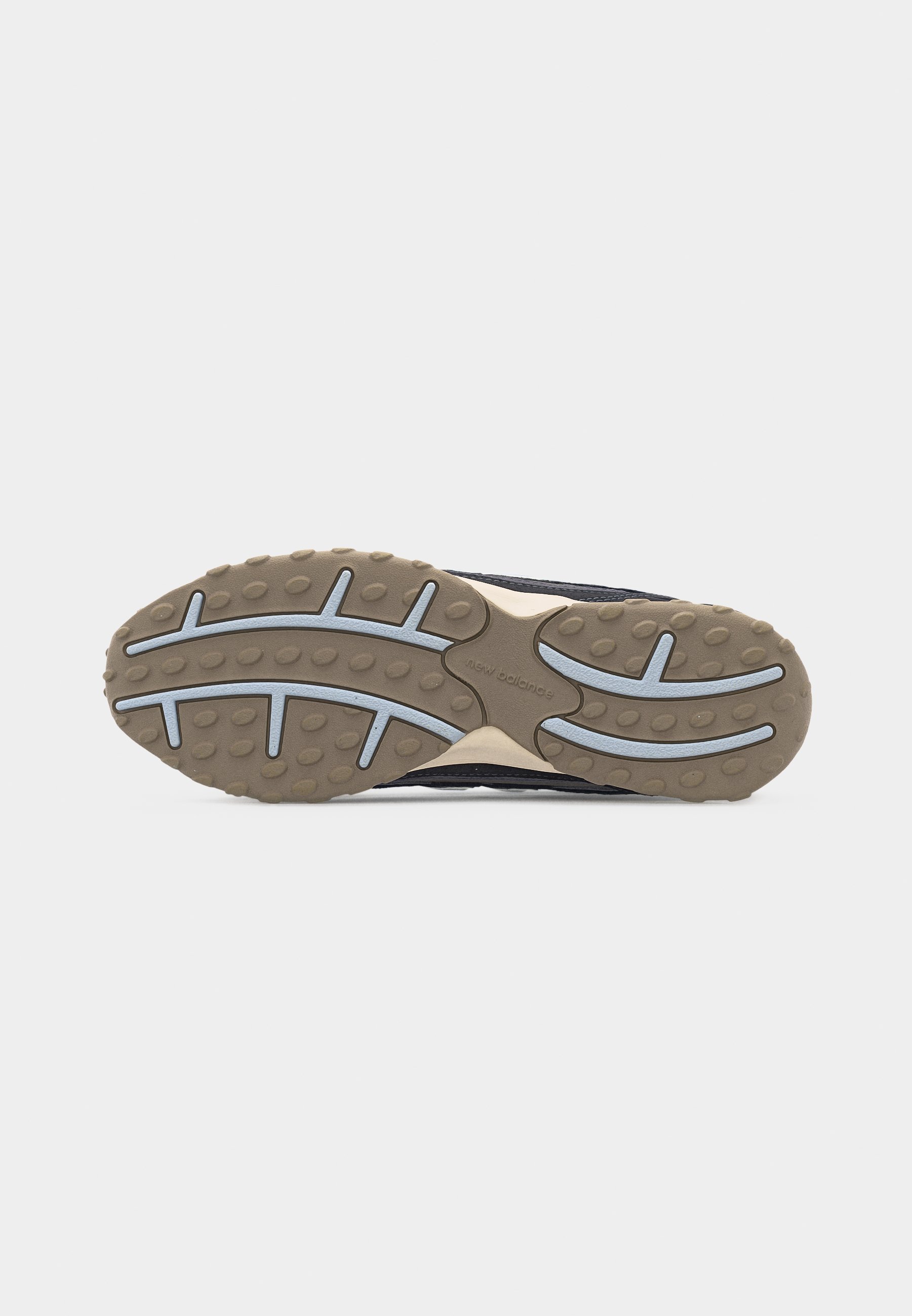 Suela de zapato con banda de rodadura de goma beige que presenta agarres circulares elevados y líneas de tracción curvas azules sobre un fondo blanco.