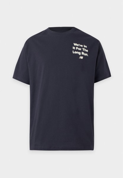 Camiseta negra de manga corta con texto blanco en la parte superior izquierda que dice "We're In It For The Long Run" y un pequeño logo de New Balance debajo.