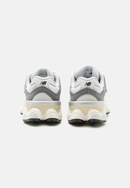 Par de zapatillas New Balance en gris y blanco vista desde atrás, con cuellos acolchados y suelas gruesas y moldeadas.
