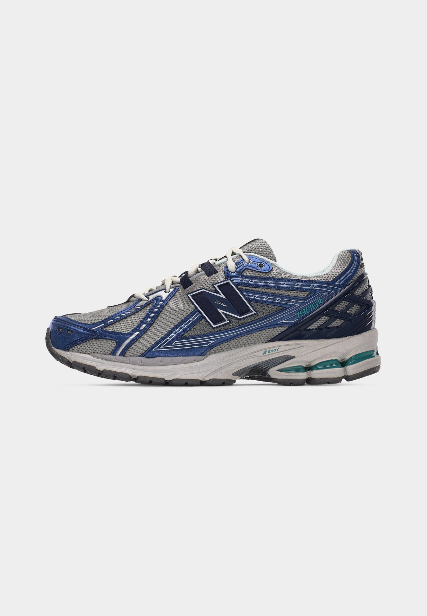 Zapatilla de correr New Balance 1906R en gris y azul con cordones blancos y suela acolchada, mostrada desde el lado exterior sobre un fondo blanco.