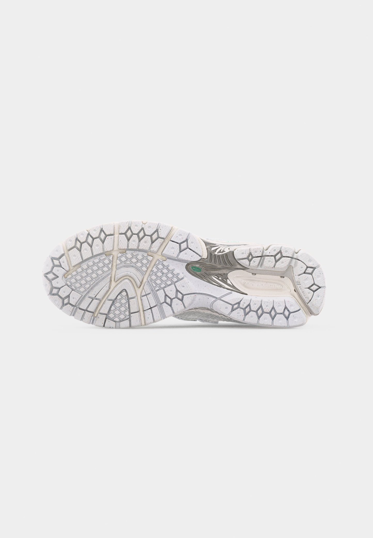 Suela de un zapato deportivo blanco y gris con un patrón de tracción de panal y cuadrícula sobre un fondo blanco liso.