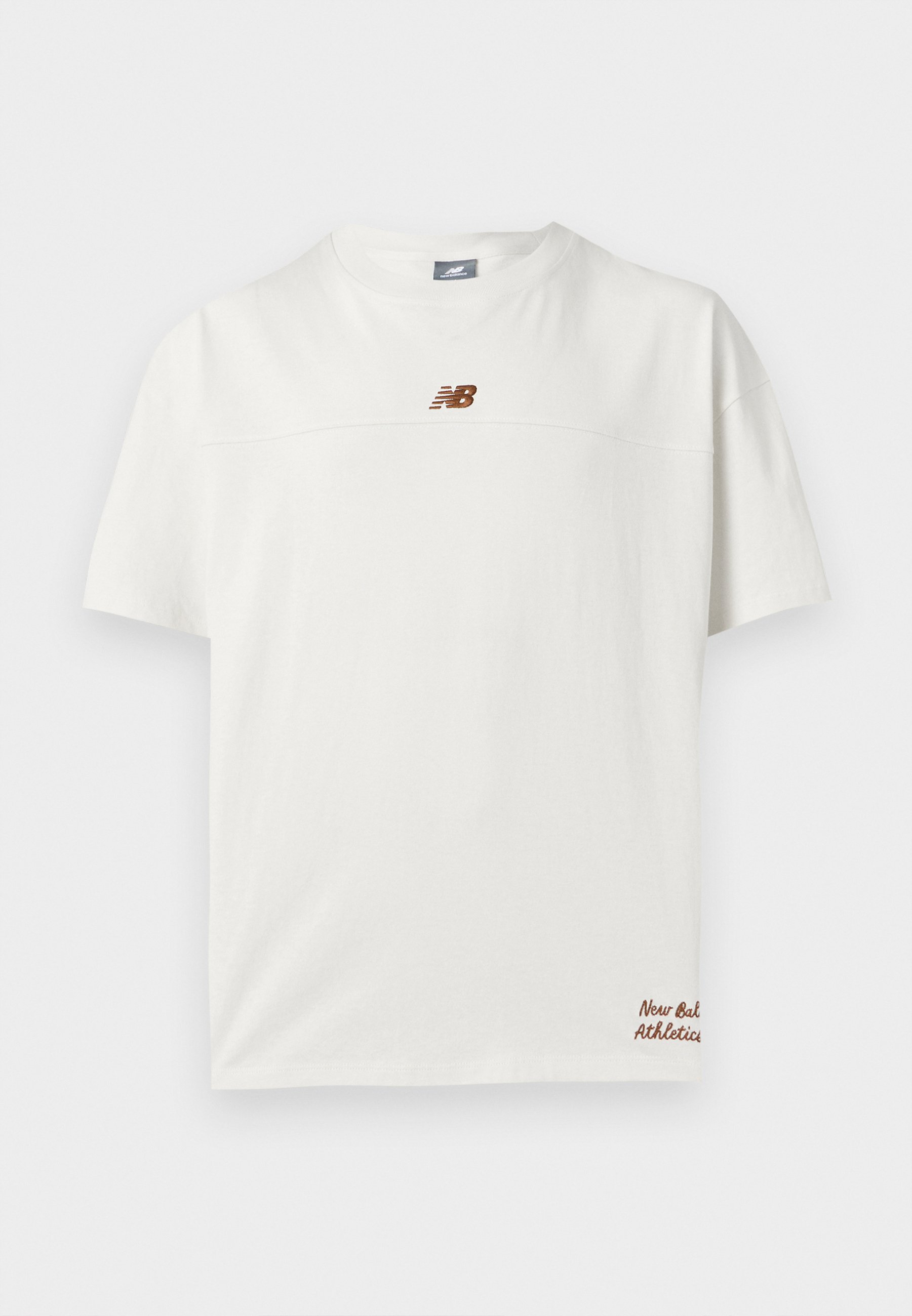 Camiseta blanca de manga corta con pequeño logo marrón de New Balance en el pecho y texto "New Balance Athletics" cerca del dobladillo inferior.
