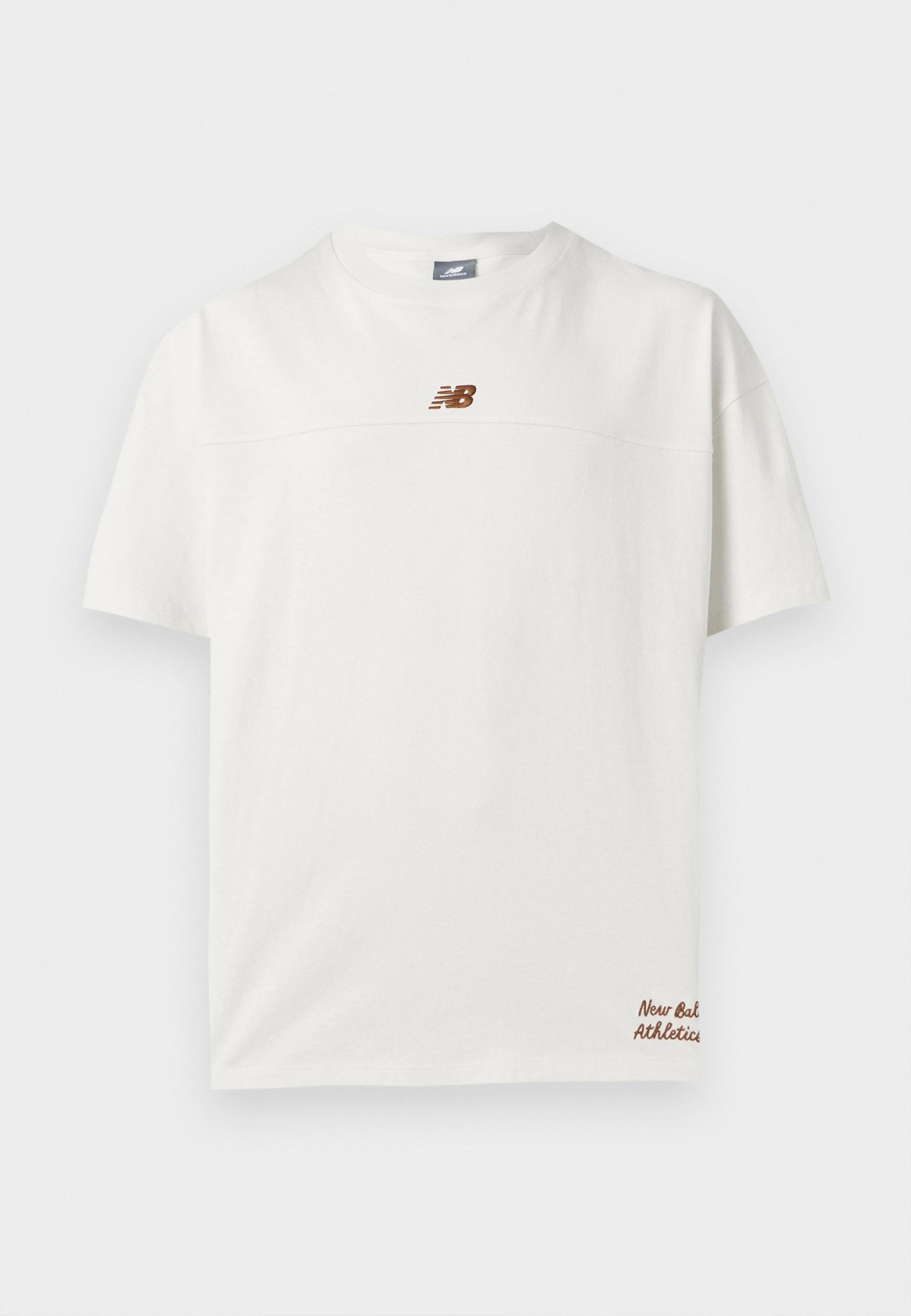 Camiseta blanca de manga corta con pequeño logo marrón de New Balance en el pecho y texto "New Balance Athletics" cerca del dobladillo inferior.