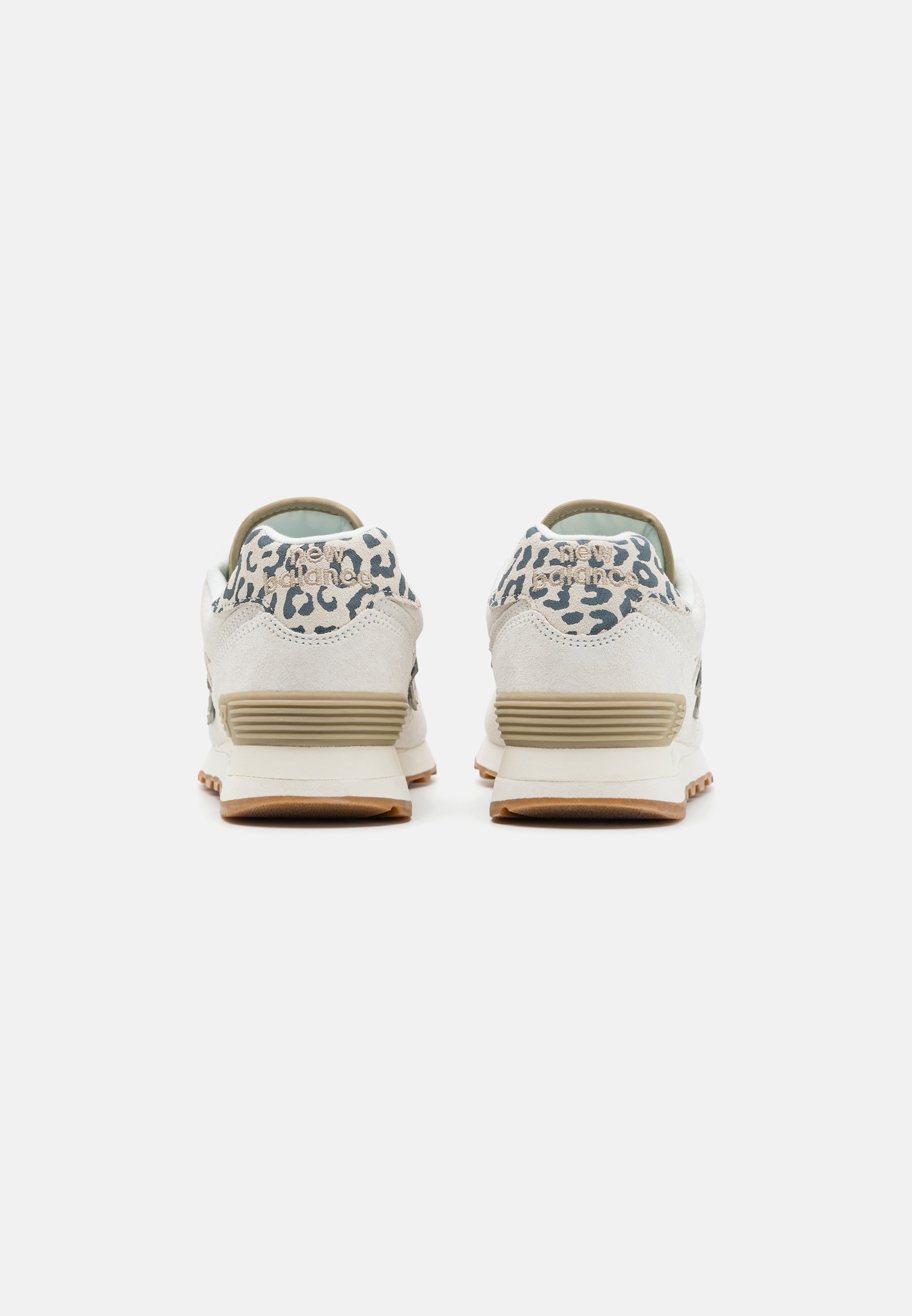 Par de zapatillas beige y blancas con detalle de estampado de leopardo en los cuellos de talón, medias suelas beige y suelas exteriores color chicle, mostradas desde atrás.