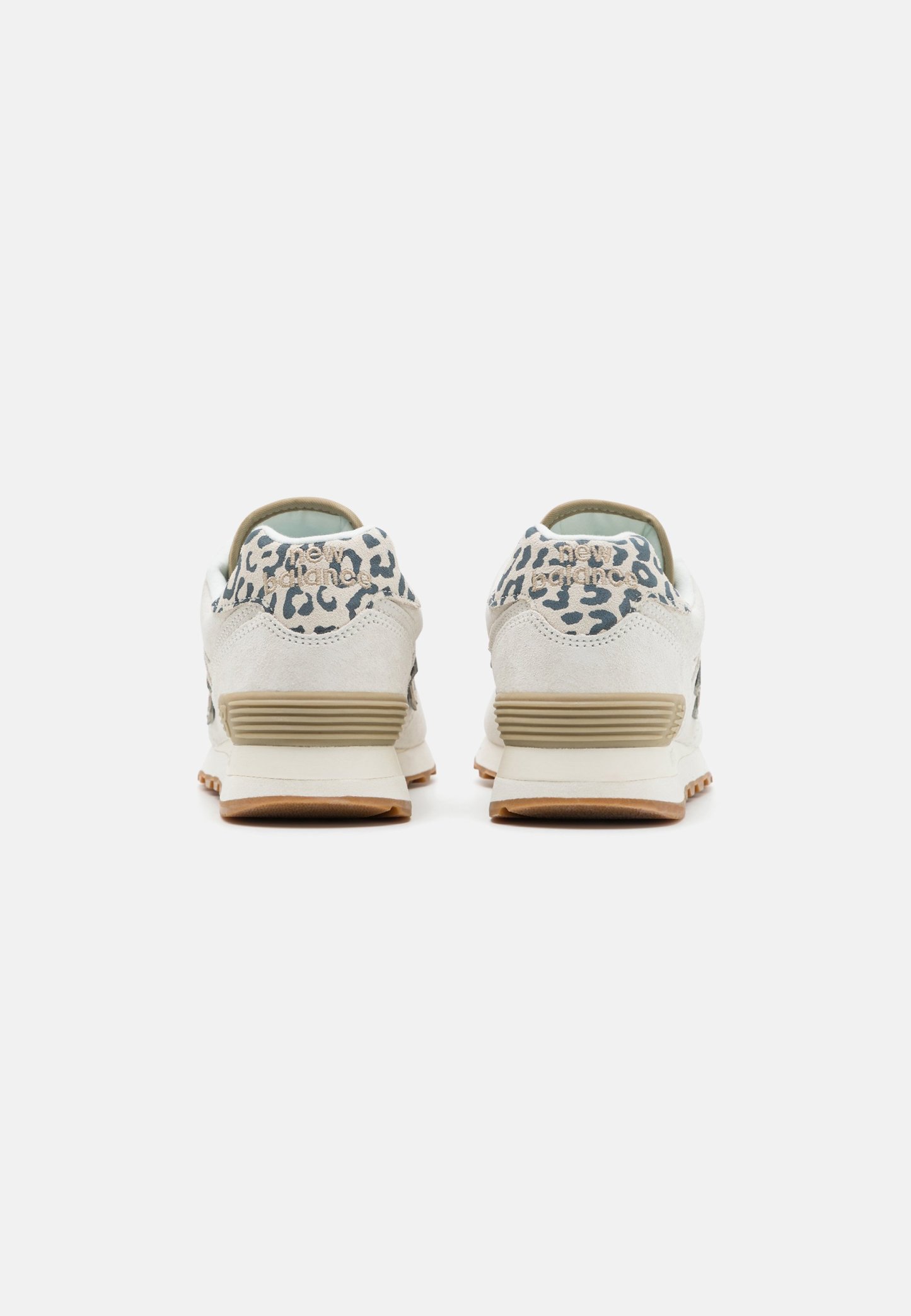 Par de zapatillas beige y blancas con detalle de estampado de leopardo en los cuellos de talón, medias suelas beige y suelas exteriores color chicle, mostradas desde atrás.