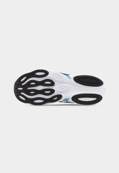 Suela de una zapatilla de correr blanca y turquesa con almohadillas de tracción de goma negra con patrones curvos y ovalados.