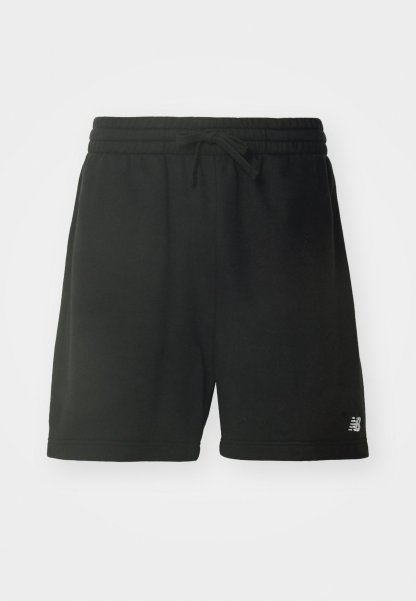 Pantalones cortos deportivos de algodón negro con una cintura elástica, cordón ajustable y detalle del logo en la parte inferior de la pierna izquierda. Textura suave.