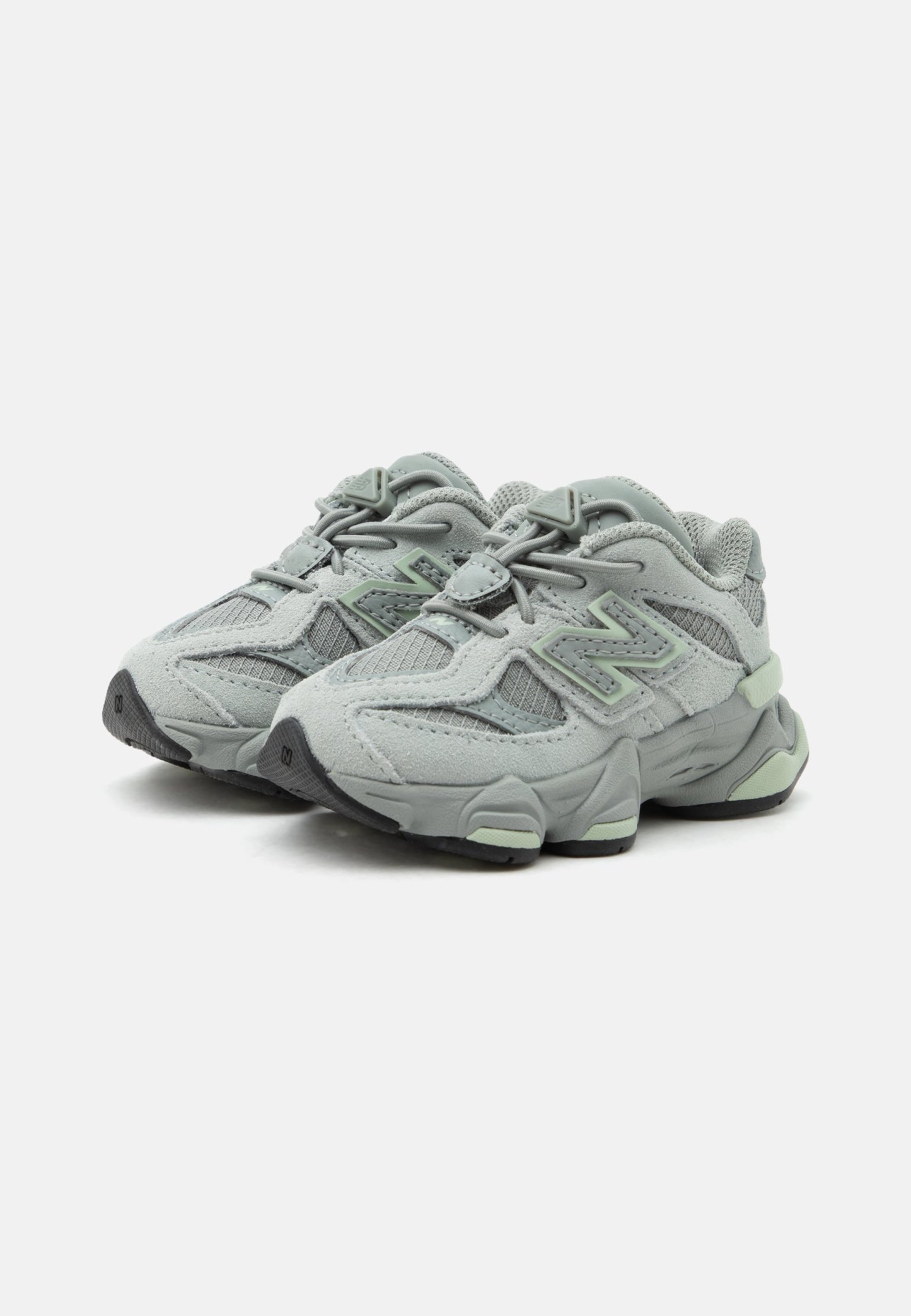 Par de zapatillas deportivas gris claro con paneles de malla y ante, suelas acolchadas y cierre de cordones en un fondo blanco liso.