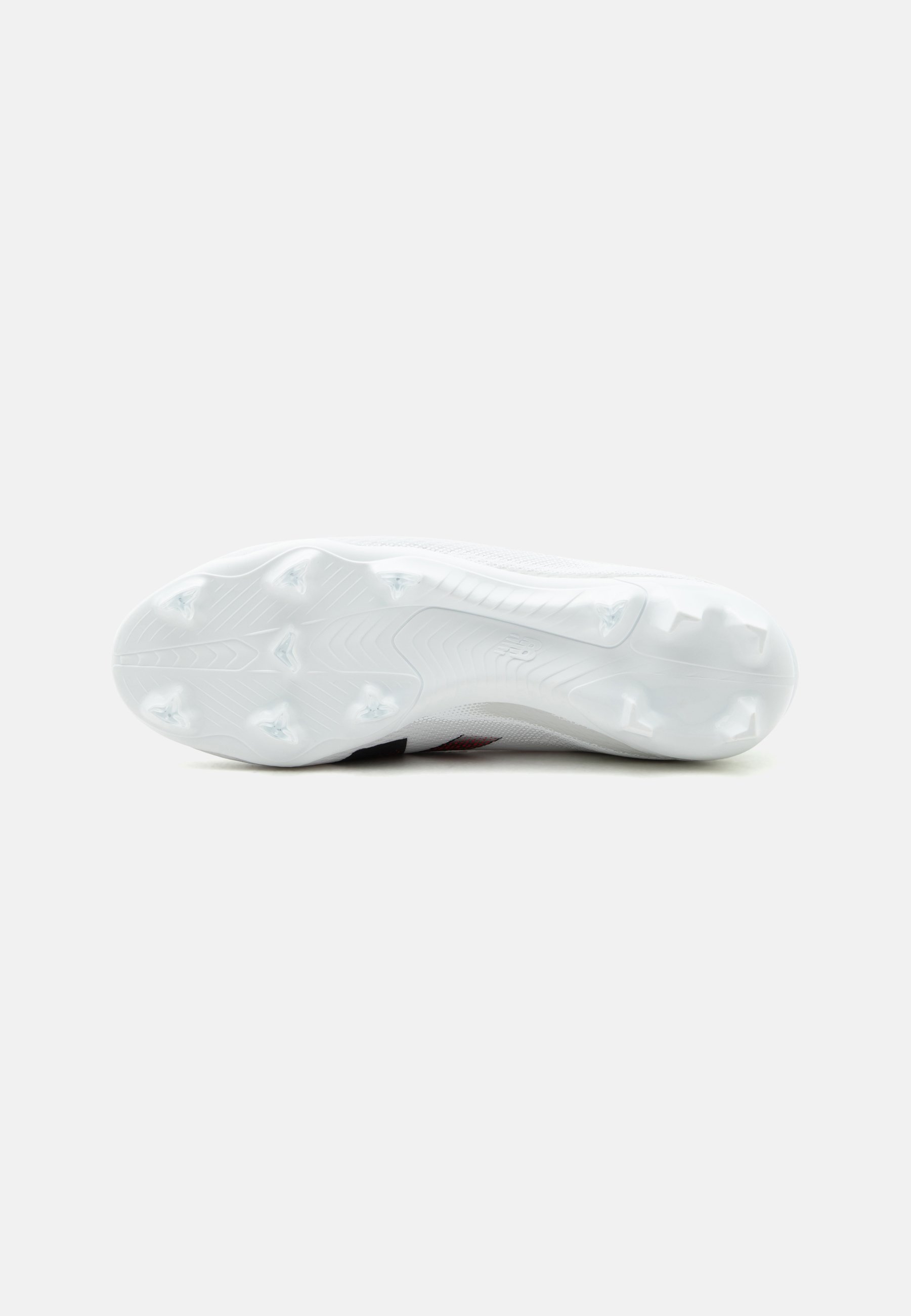 Suela blanca de bota de fútbol con múltiples tacos cónicos y en forma de cuchilla para tracción en superficies de césped, vista desde abajo.