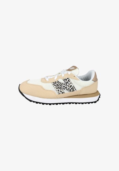 Zapatilla beige y blanca con paneles de malla, logo "N" con estampado de leopardo, cordones blancos y suela negra con dibujo.