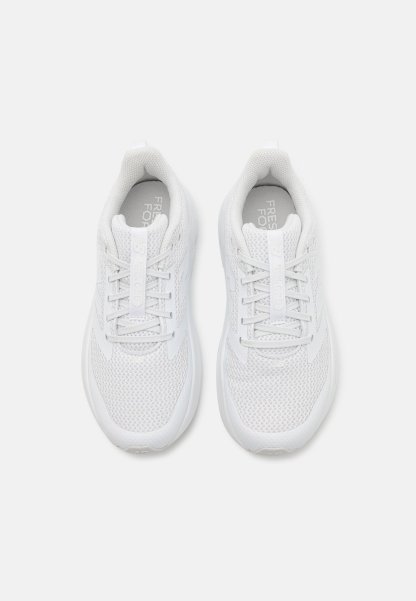Zapatillas deportivas blancas con parte superior de malla, cierre de cordones, cuello acolchado y suela texturizada. Marca visible en la lengüeta y la plantilla.