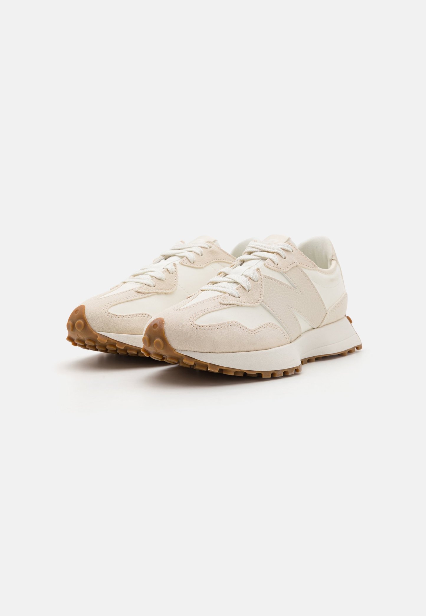 Zapatillas color crema con una combinación de materiales lisos y texturizados, que cuentan con una suela acolchada, diseño con cordones y una suela de goma moldeada.