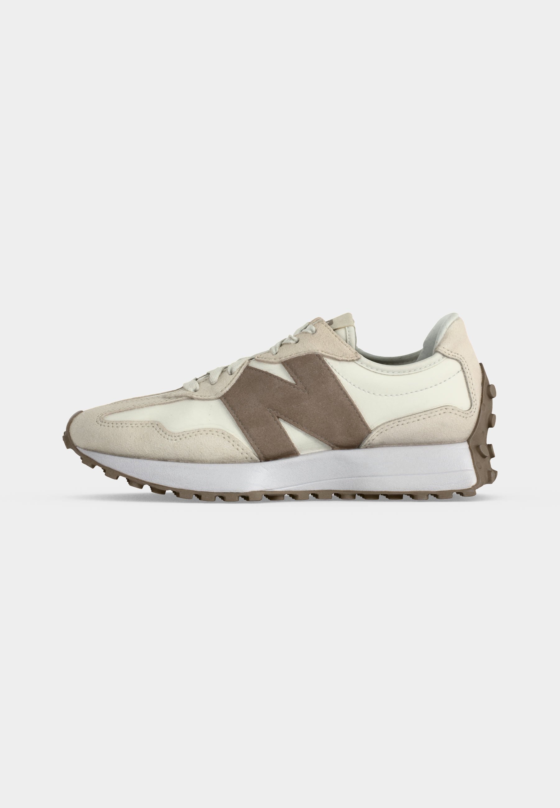 Zapatilla beige y blanco roto con logo "N" de ante marrón, media suela blanca y suela exterior marrón rugosa, vista lateral.