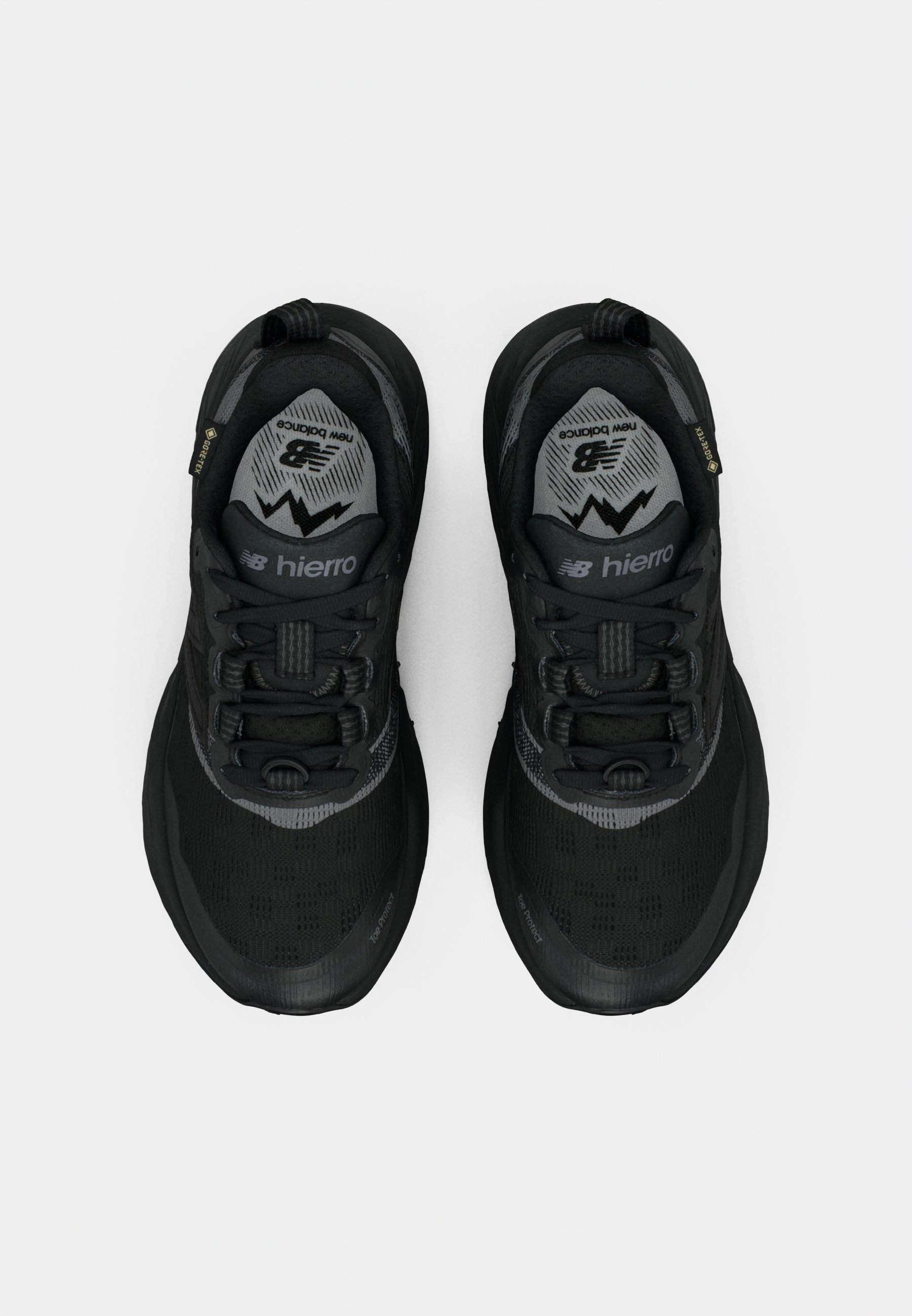 Zapatos deportivos negros con parte superior de malla, suela de goma texturizada, acentos reflectantes y un cuello acolchado. Presenta un diseño con cordones.