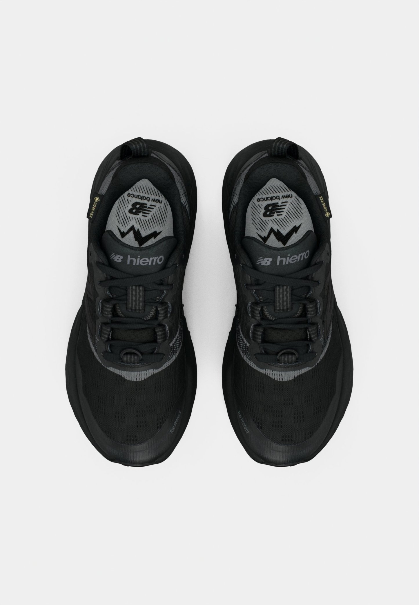 Zapatos deportivos negros con parte superior de malla, suela de goma texturizada, acentos reflectantes y un cuello acolchado. Presenta un diseño con cordones.