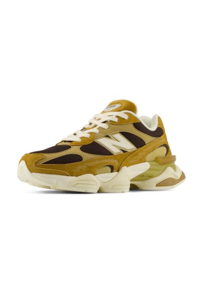 Zapatilla New Balance marrón y beige con cordones blancos y suela gruesa acolchada, mostrada en un ligero ángulo sobre fondo blanco.