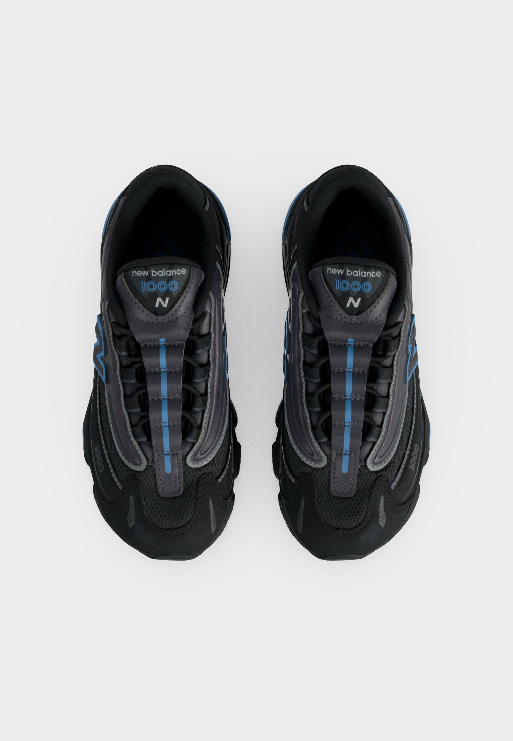 Par de zapatillas negras New Balance 1000 con detalles azules, vistas desde arriba sobre un fondo blanco.