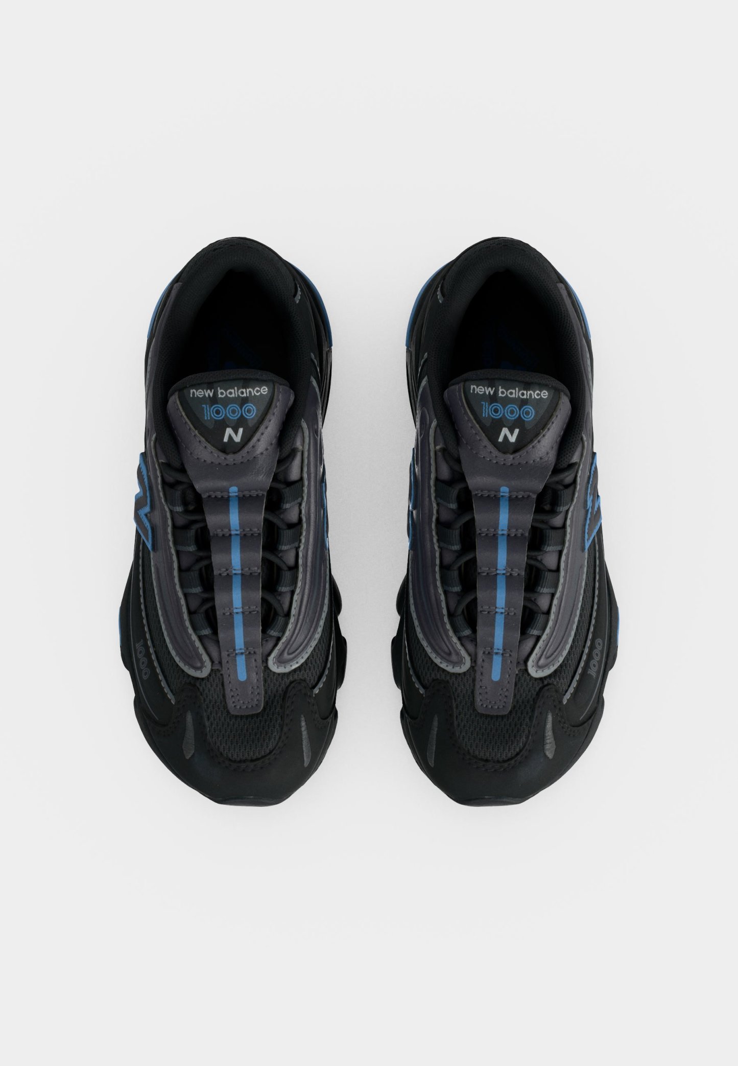 Par de zapatillas negras New Balance 1000 con detalles azules, vistas desde arriba sobre un fondo blanco.