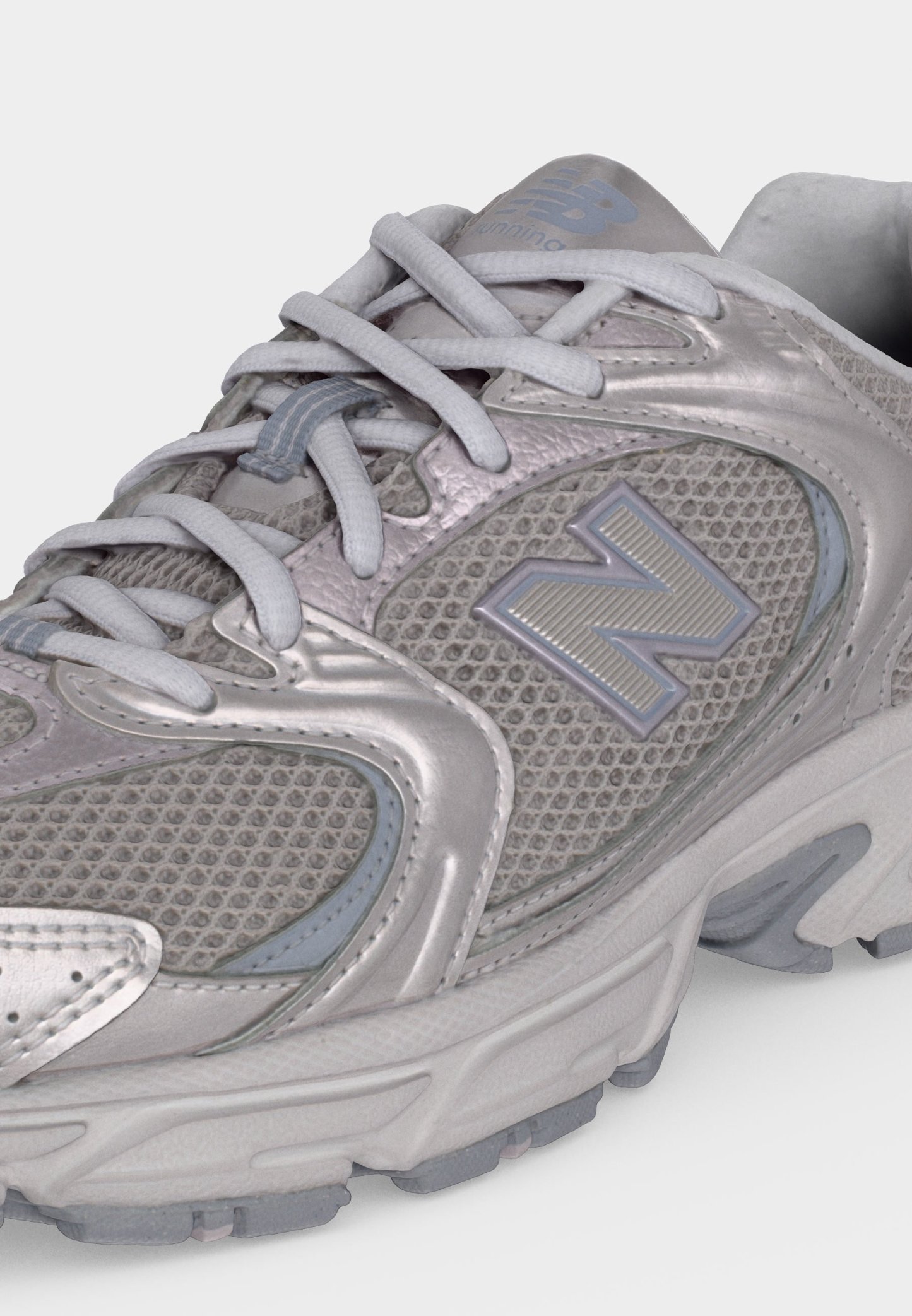 Zapatilla de running New Balance gris con parte superior de malla y sintética, cordones atados y una suela gruesa y acolchada.