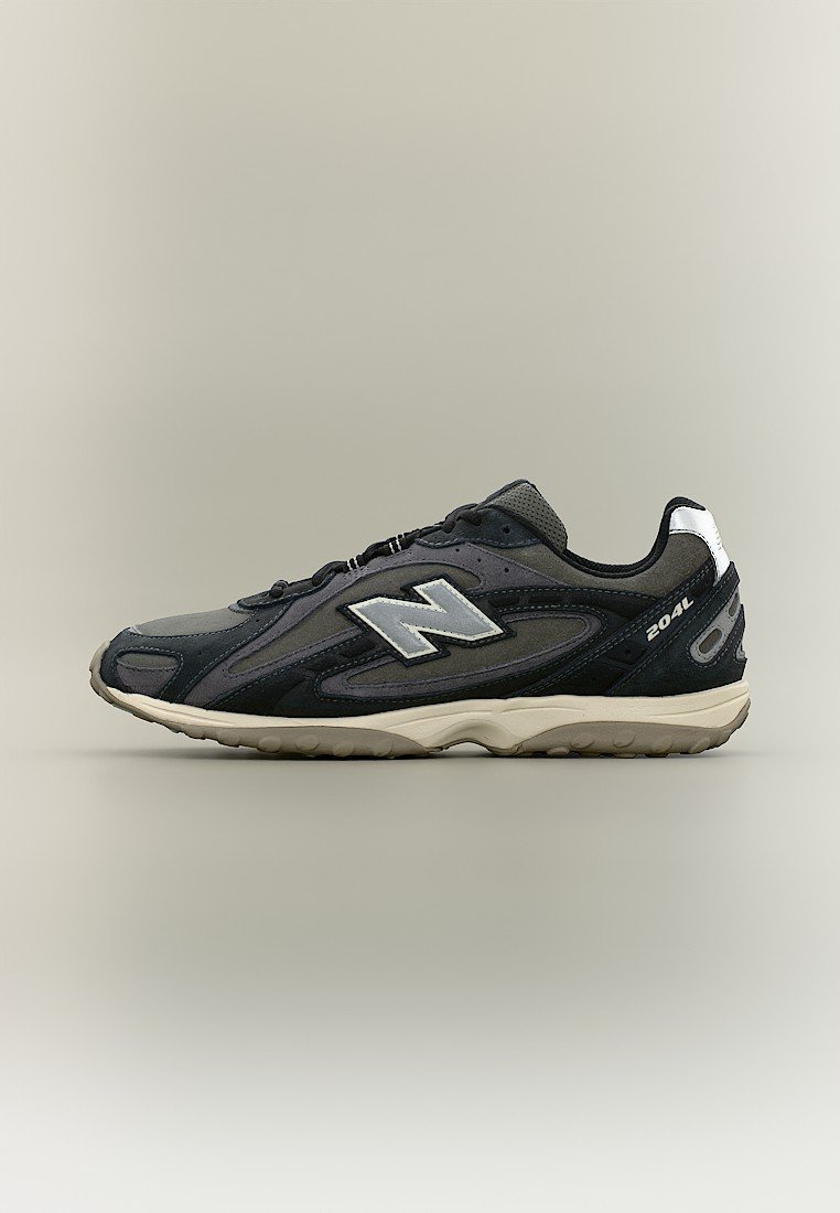 Zapatilla New Balance 204L en negro y gris con logo blanco y suela beige sobre un fondo neutro.