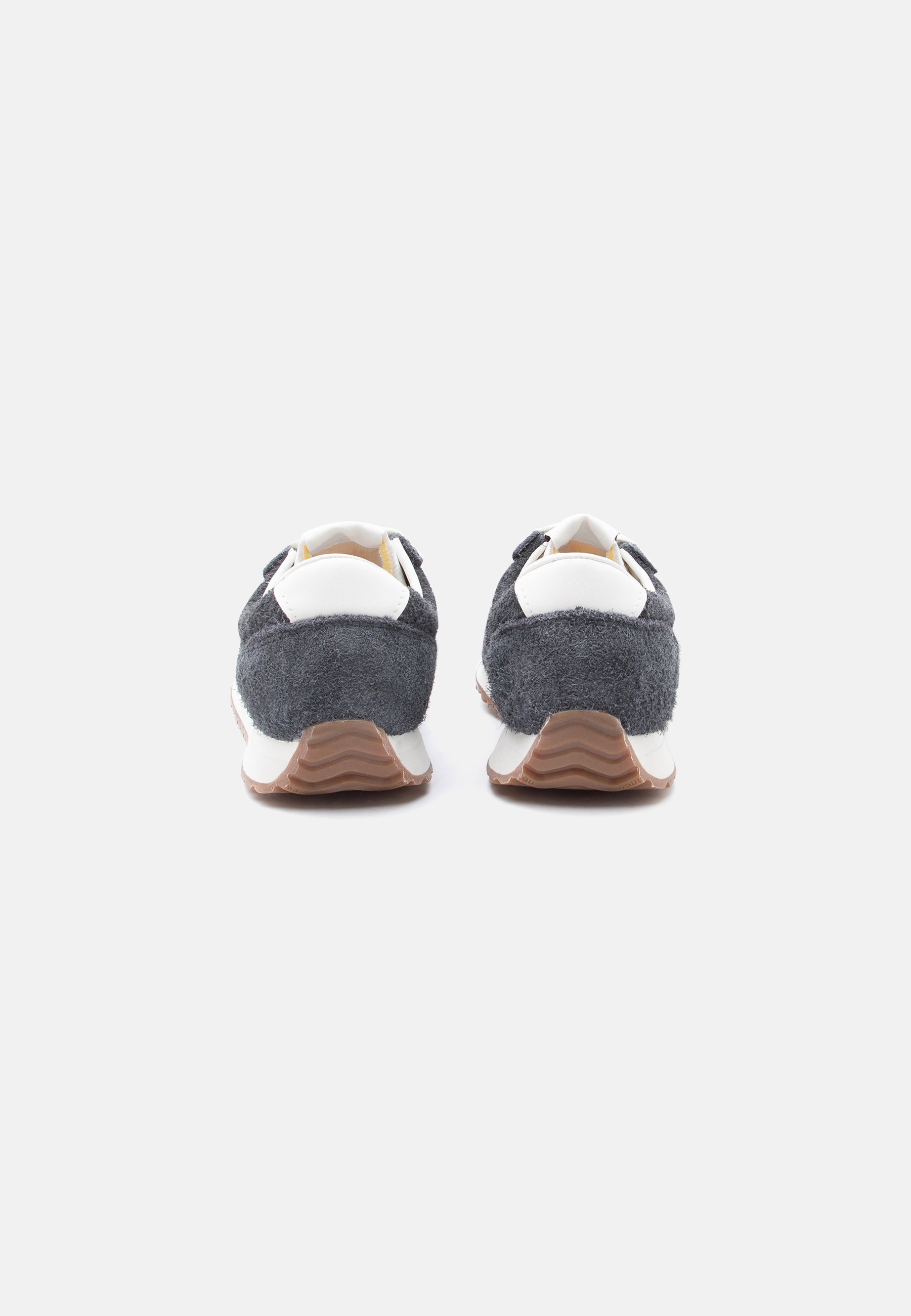 Par de zapatillas deportivas en gris oscuro y blanco con tejido texturizado, detalles blancos en el talón y suelas de goma marrón, vistas desde atrás sobre un fondo blanco.
